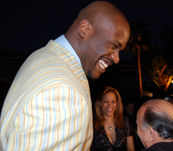 Miami Heat center Shaquille O'Neal laughs with his wife, Shaunie, and guests on his driveway before a team benefit at his Star Island home.