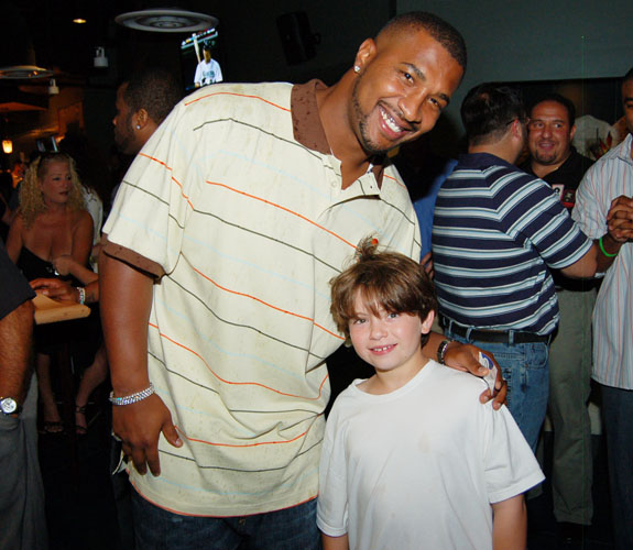 Miami Dolphins quarterback Daunte Culpepper poses with a young fan at the grand opening celebration of Rivals at the Westin Diplomat in Hollywood Beach, Fla.