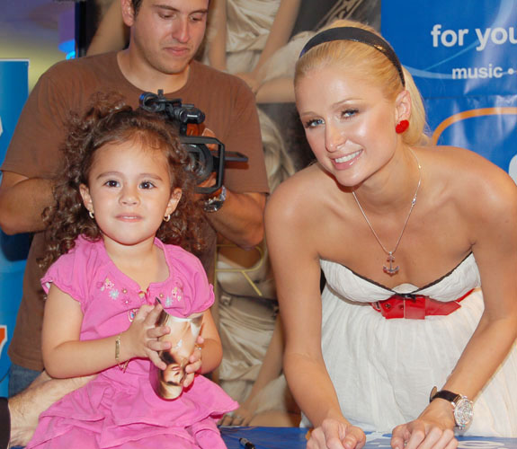 Socialite and heir to the Hilton Hotels empire Paris Hilton poses with a young fan at the FYE store at the corner of Fifth and Washington on Miami Beach, Fla.